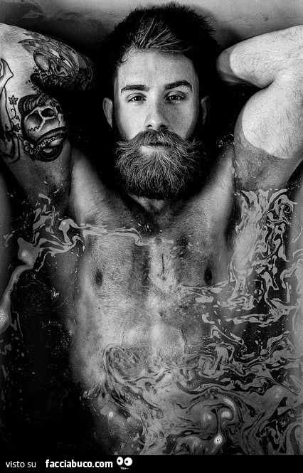 Uomo sexy con barba e tatuaggi